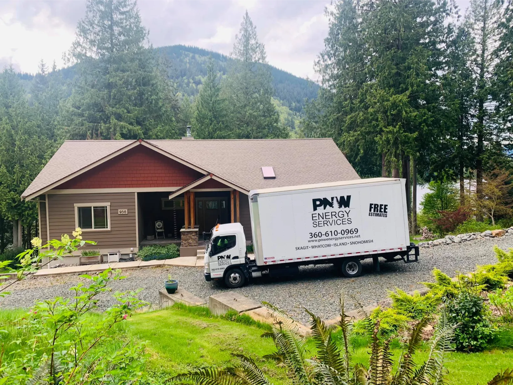 PNW Construction & Energy Services truck parked in front of a mountain home, offering free energy efficiency estimates in Washington state.